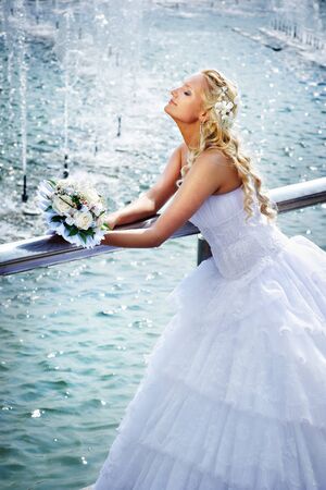Happy bride with bouquet of flower at wedding walk in the parkの写真素材