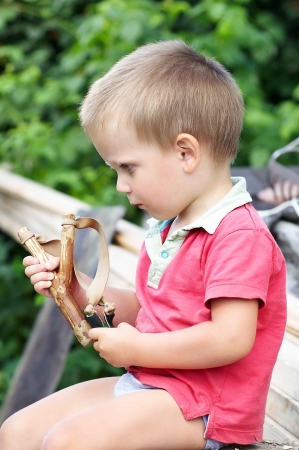 Little boy with slingshot in his handの写真素材