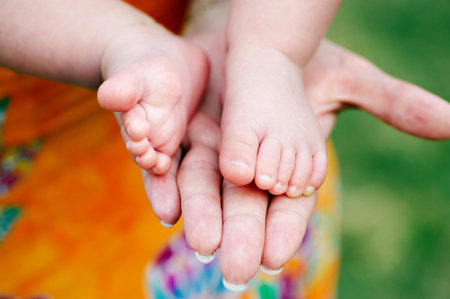 Little foots baby in the palm of the mother