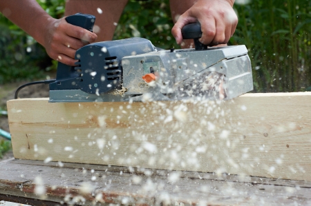 Carpenter with electric plane outdoorsの写真素材