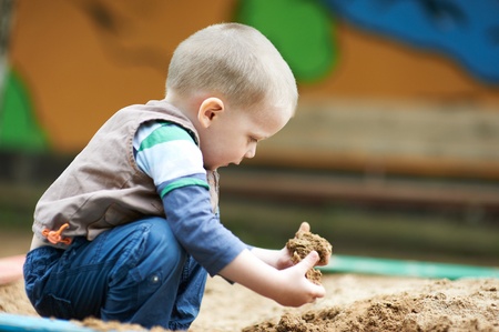 Little child plays with sand outdoorsの写真素材