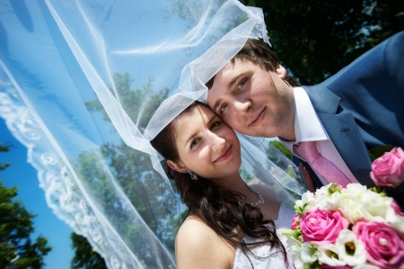 Happy bride and groom in park at the wedding walkの写真素材