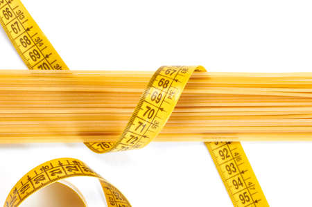 Spaghetti and measuring tape on white backgroundの写真素材