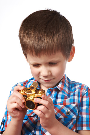 Little boy reporter photographer shooting with gold retro camera isolated close-upの写真素材