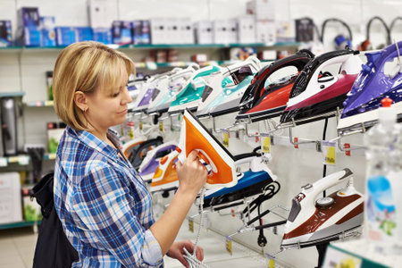 Woman housewife shopping for iron, smilingの写真素材