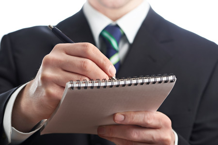 Businessman writing in a notebook isolatedの写真素材