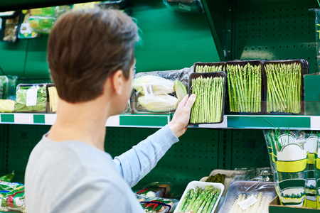 Man buys a asparagus in the storeの写真素材