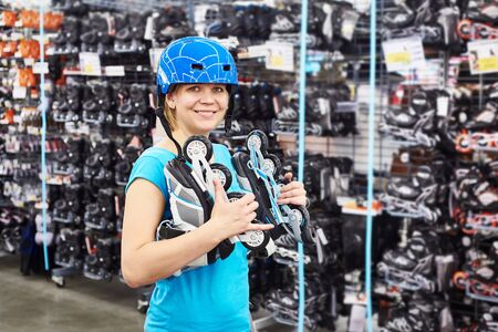 Girl in a helmet and with rollers in the sports shopの写真素材