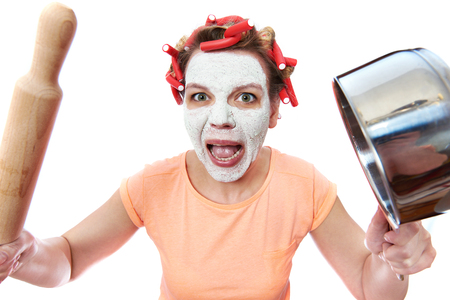 Funny housewife with roller-pin and pan over whiteの写真素材