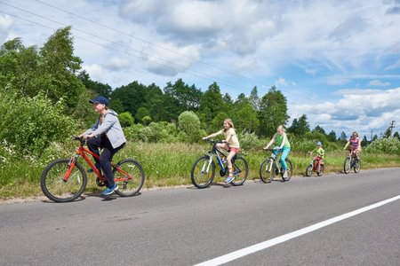 Happy kids on a bike ride on a country roadの写真素材