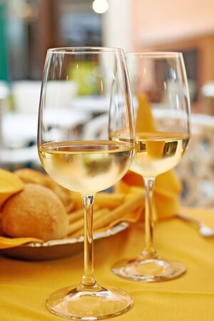 Glasses of white wine and a salad on the table cafeの写真素材