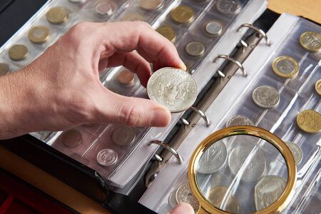 American dollar in hands of numismatist and magnifying glassの写真素材