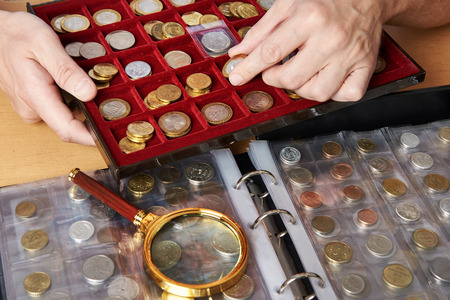 Numismatist with his collection of coins close-upの写真素材