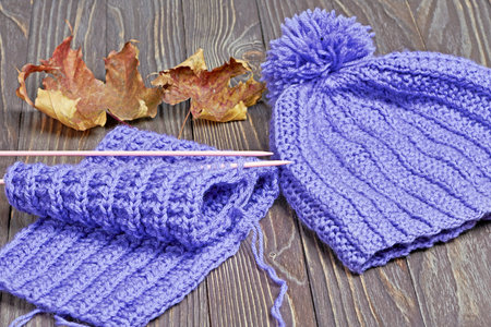 Knitted colorful scarf and hat on wooden backgroundの写真素材