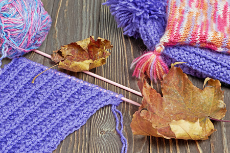Knitted colorful scarf and hats on wooden backgroundの写真素材