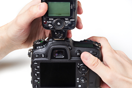 Photographer to set the external flash on a digital SLR cameraの写真素材