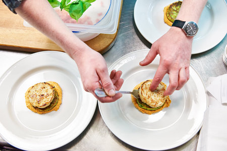 Cook are served at dish with fish cutlet in a restaurant