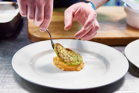 Cook are served at dish with vegetable cutlet in a restaurantの写真素材