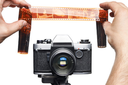 Hands with color negative near SLR camera isolated white