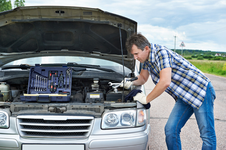 Man with tools near his broken carの写真素材