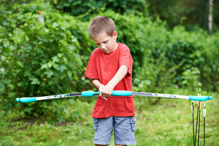 Little archer with bow and arrows outdoors