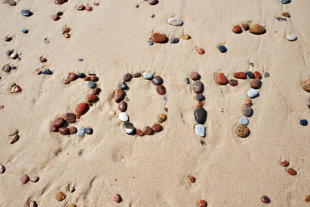 Number of wet stones in 2017, laid out by on the sand beachの写真素材
