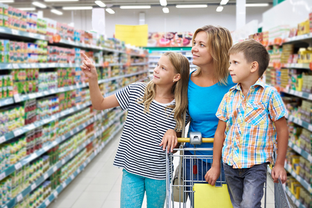 Mother and children are choosing products in shopの写真素材