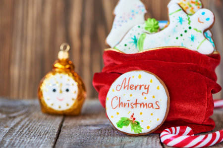 Toy alarm clock and christmas gingerbread on wooden backgroundの写真素材
