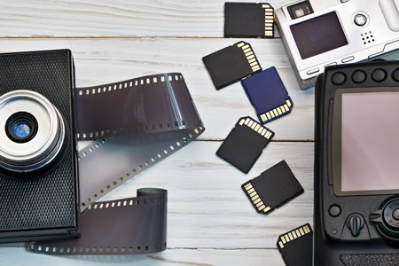 Retro camera with film and modern digital compact and DSLR with SD cards