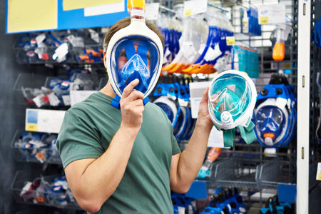 Man chooses a mask for scuba diving in the storeの写真素材