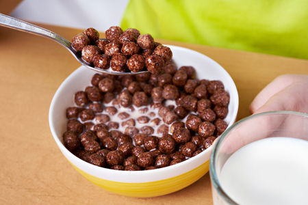 Cereal chocolate balls and glass of milk on breakfastの写真素材