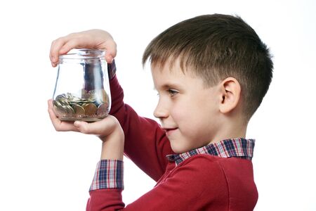 Beautiful little boy with glass jar of coins in his hands isolated whiteの写真素材