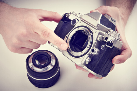 Photographer shows the mechanism of auto focus SLR camera. Retro styleの写真素材