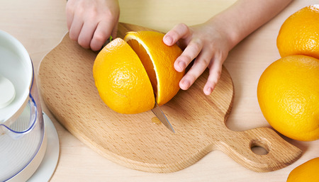Child cutting knife orange closeupの写真素材