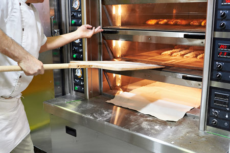 Baker bakes bread in the oven