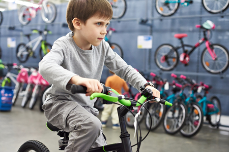 Boy riding a bicycle in a sports supermarketの写真素材