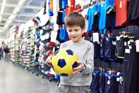 Boy with a soccer ball in a sports storeの写真素材
