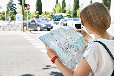 Smartphone with GPS navigator and map in the hands of a woman tourist