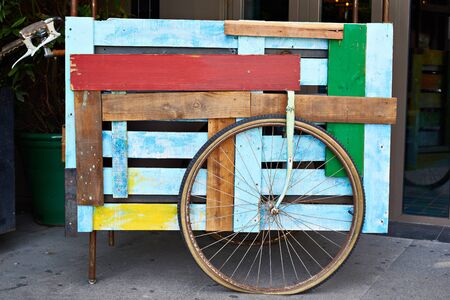 Decorative colored wooden cart with a wheelの写真素材