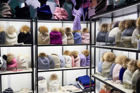 Winter colorful hats with fur pompom in the shop windowの写真素材