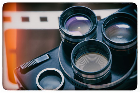 Old retro movie camera on the background of a perforation of filmの写真素材