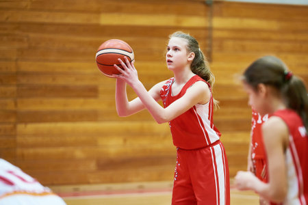 Girl basketball player throws the ball in the gameの写真素材