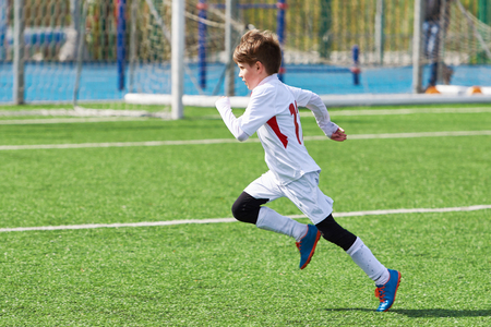 Running boy soccer player training on the football fieldの写真素材