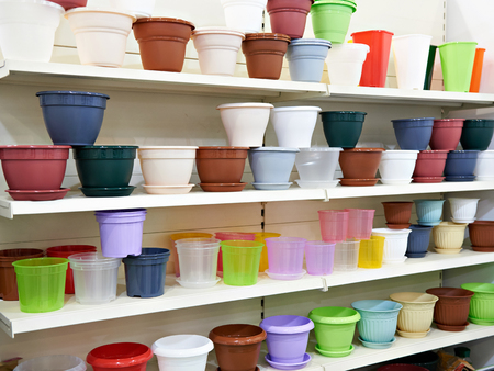 Colored plastic flower pots on the counter in the storeの写真素材