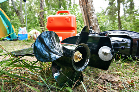 Screw propeller of boat motor, canister with gasoline and camping tent outdoorsの写真素材
