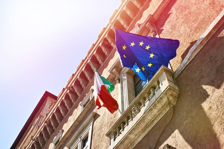 Flags of Italy and the European Union against the background of a clear blue skyの写真素材