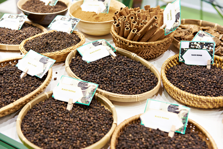 Black pepper in wooden plates on the marketの写真素材