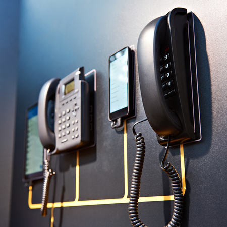 Office telephones and modern smartphones and tablets on the webの写真素材