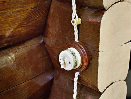 Retro style light switch on a wall of logsの写真素材