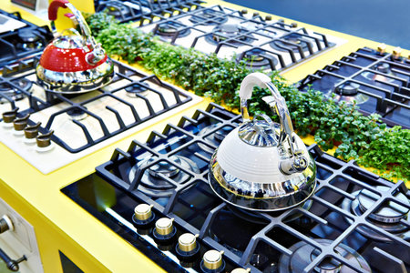 New kettles on the gas stove at the exhibition in the store